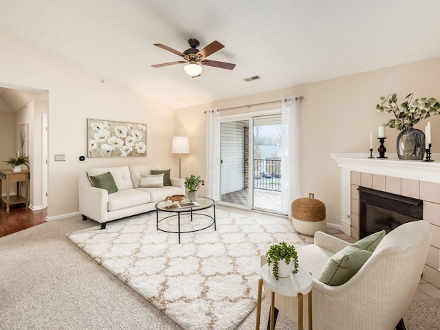 living room featuring ceiling fan, wood-type flooring, lofted ceiling, and a fireplace