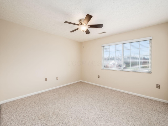 carpeted spare room with ceiling fan and a textured ceiling