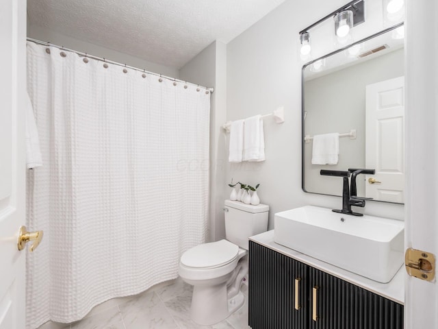 bathroom featuring vanity, a textured ceiling, and toilet