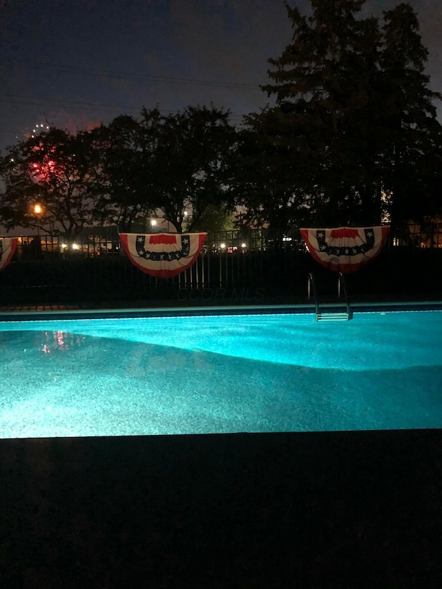 view of pool at twilight