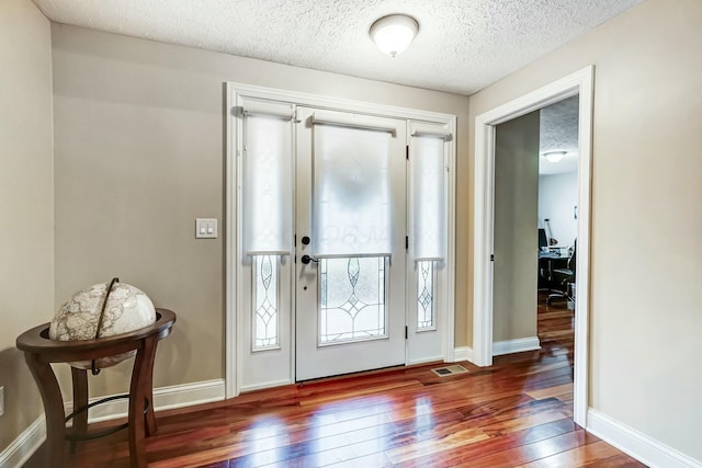 foyer featuring a textured ceiling and dark hardwood / wood-style floors