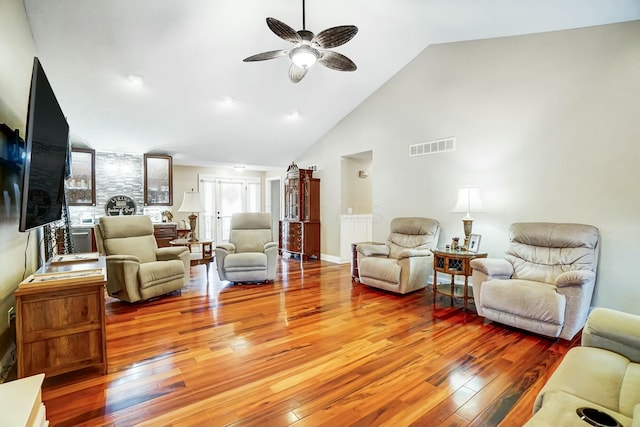 living room featuring ceiling fan, lofted ceiling, and light wood-type flooring