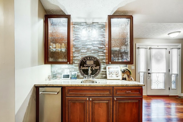 kitchen featuring light stone countertops, a textured ceiling, dark hardwood / wood-style flooring, and backsplash