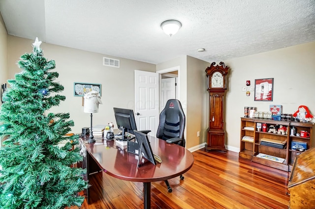 home office featuring hardwood / wood-style floors and a textured ceiling