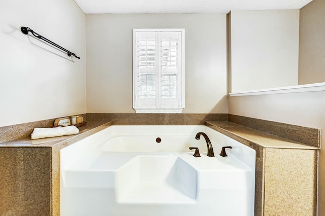 bathroom featuring a tub and a textured ceiling