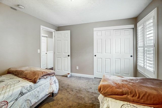 carpeted bedroom with a closet and a textured ceiling