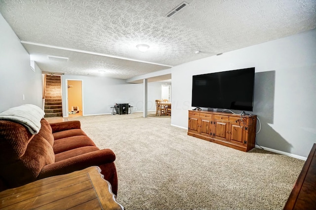 carpeted living room featuring a textured ceiling