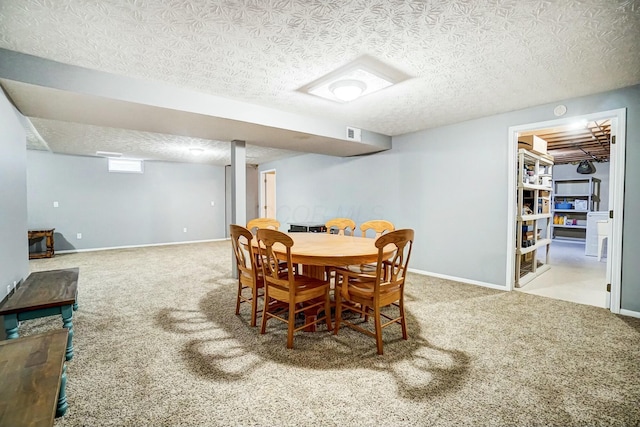 carpeted dining room featuring a textured ceiling