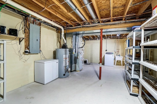 basement with gas water heater, electric panel, heating unit, refrigerator, and washer and clothes dryer