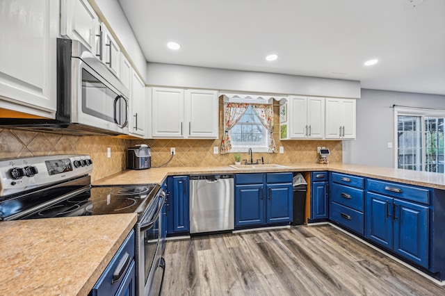 kitchen with white cabinetry, stainless steel appliances, and blue cabinets