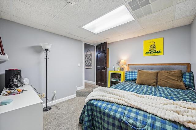 bedroom featuring carpet and a drop ceiling