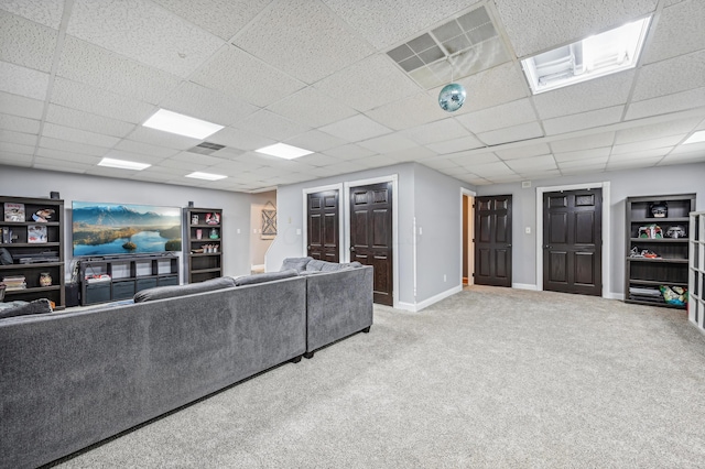 carpeted living room with a drop ceiling