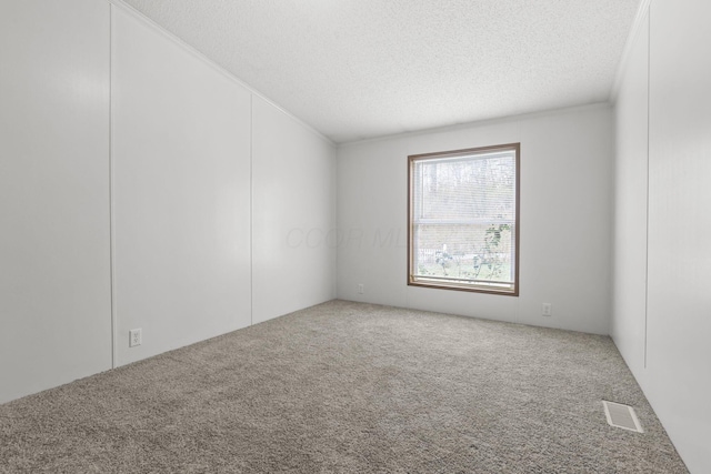 carpeted empty room with a textured ceiling