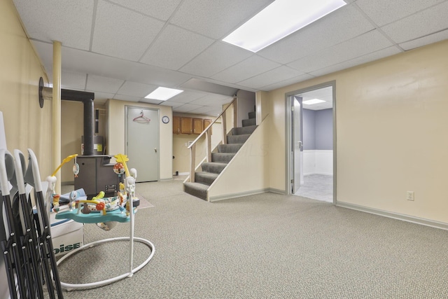 basement with a paneled ceiling and light carpet