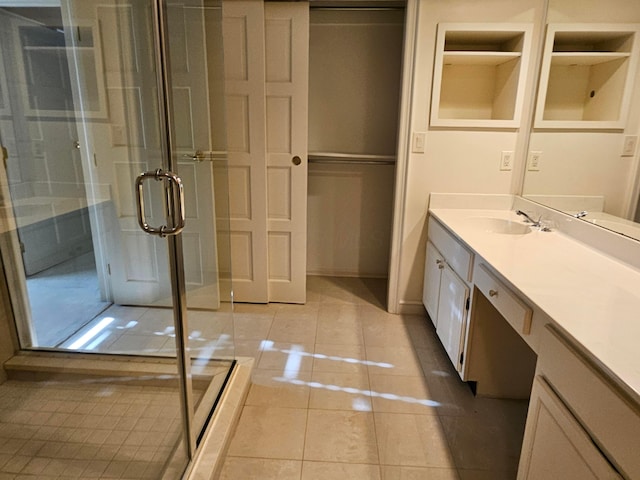 bathroom with tile patterned floors, vanity, and a shower with door