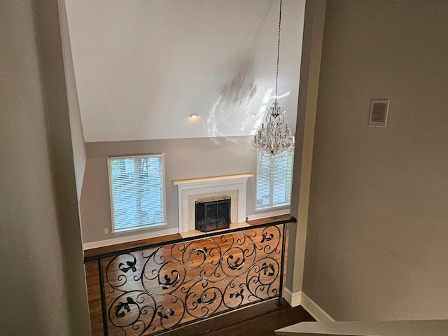 living room featuring wood-type flooring, vaulted ceiling, and an inviting chandelier