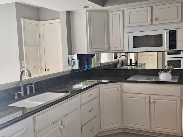 kitchen with white cabinets, white appliances, and sink