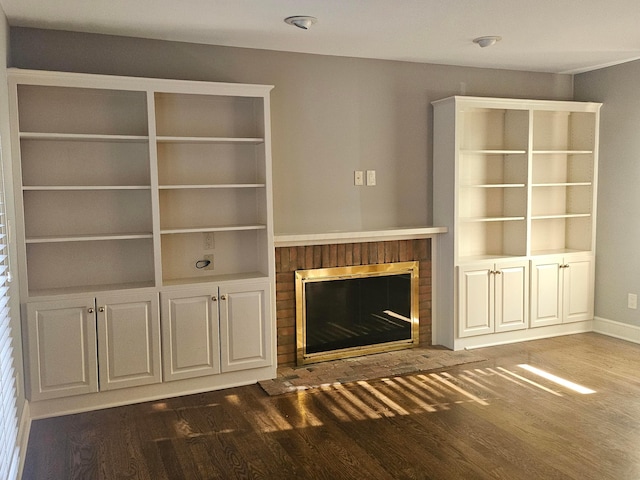 unfurnished living room with a fireplace and dark wood-type flooring