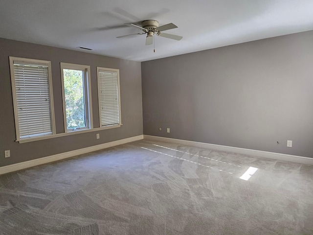 spare room featuring ceiling fan and carpet