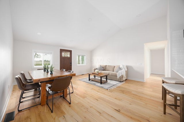 dining room featuring lofted ceiling and light hardwood / wood-style flooring