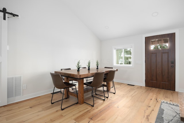 dining room with light hardwood / wood-style flooring and lofted ceiling