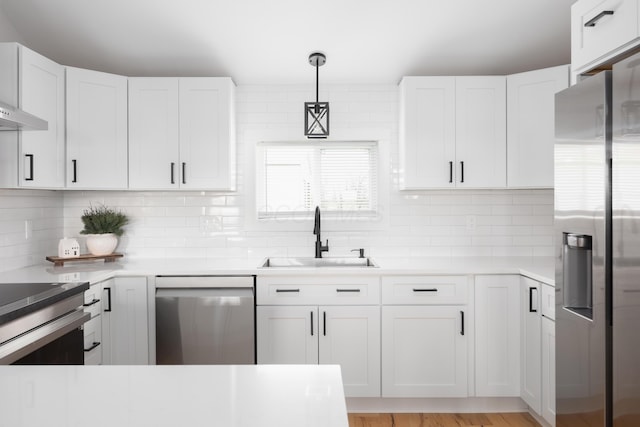 kitchen featuring hanging light fixtures, sink, decorative backsplash, appliances with stainless steel finishes, and white cabinetry