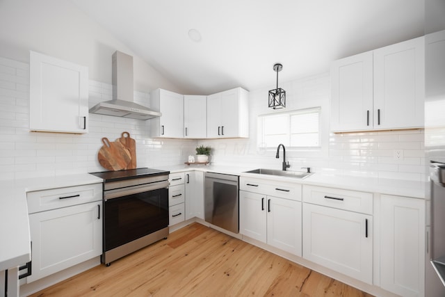 kitchen with white cabinets, sink, wall chimney exhaust hood, and appliances with stainless steel finishes