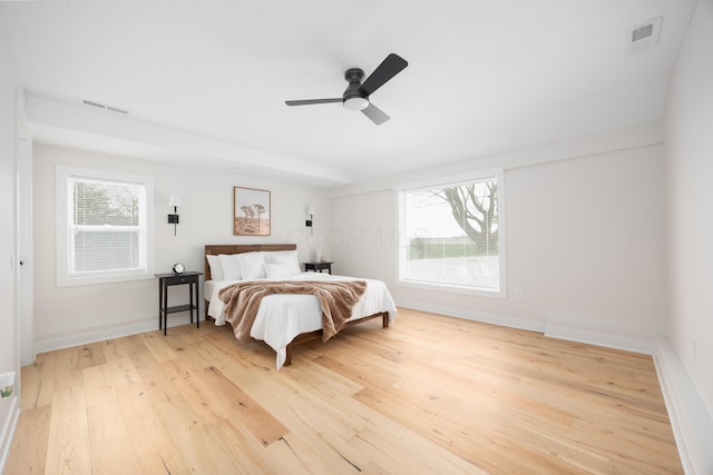 bedroom with multiple windows, hardwood / wood-style floors, and ceiling fan