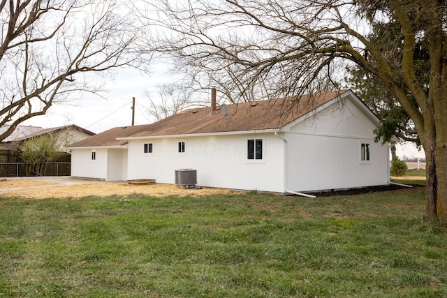 rear view of property featuring central AC and a yard