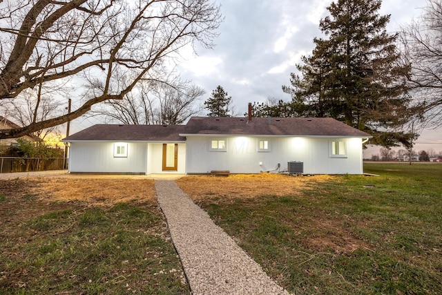 single story home with a front lawn and central AC unit