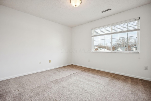 carpeted empty room with a textured ceiling