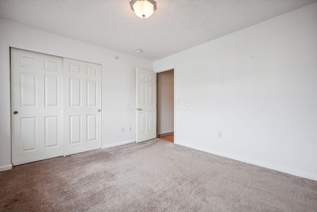 unfurnished bedroom featuring a closet, carpet floors, and a textured ceiling