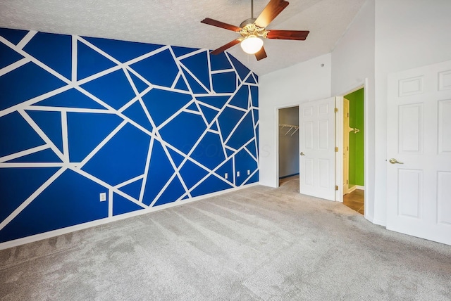 carpeted spare room featuring a textured ceiling and ceiling fan