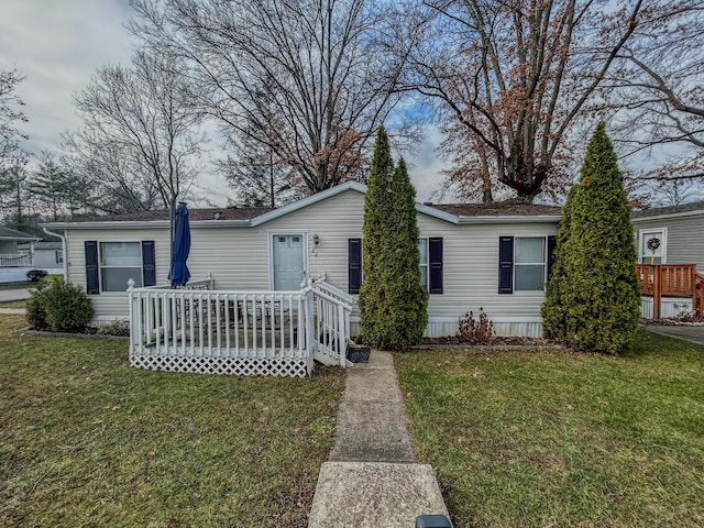 view of front of house with a wooden deck and a front yard