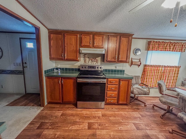 kitchen with light hardwood / wood-style floors, electric stove, a textured ceiling, and ornamental molding