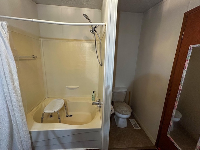 bathroom featuring a textured ceiling, tile patterned flooring, shower / bath combo, and toilet