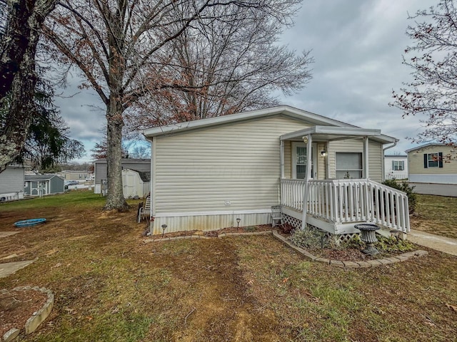 view of side of home with a lawn and a shed