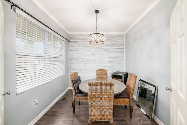 dining area with dark hardwood / wood-style flooring, crown molding, and a chandelier