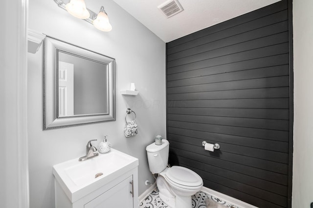 bathroom featuring vanity, a textured ceiling, and toilet