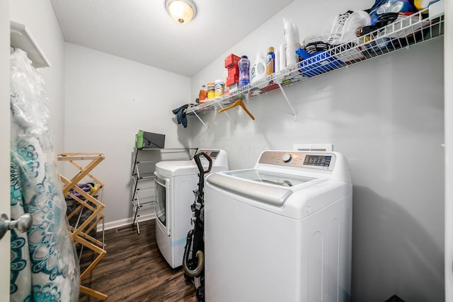 clothes washing area with dark wood-type flooring and independent washer and dryer