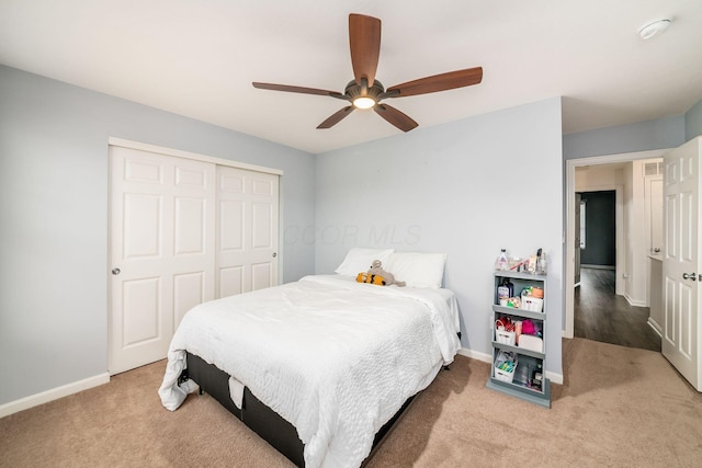 carpeted bedroom featuring ceiling fan and a closet