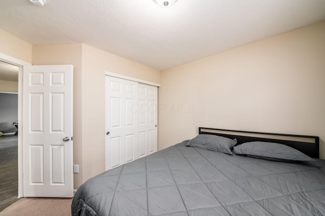 bedroom featuring a closet, carpet, and a textured ceiling