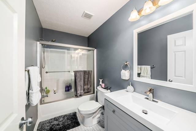 full bathroom featuring vanity, tile patterned floors, toilet, enclosed tub / shower combo, and a textured ceiling