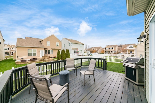 wooden deck featuring a grill and a yard