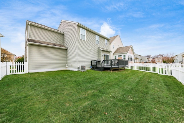 rear view of house with a yard, a wooden deck, and central air condition unit