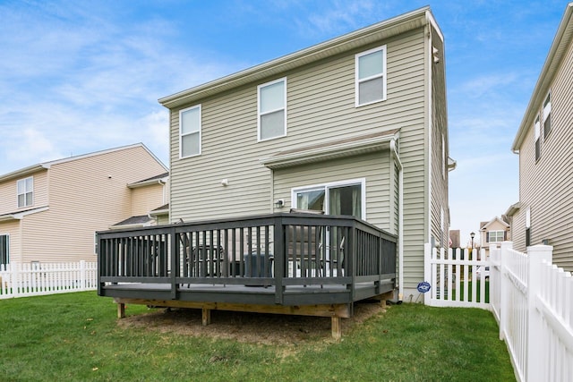 back of property with a yard and a wooden deck