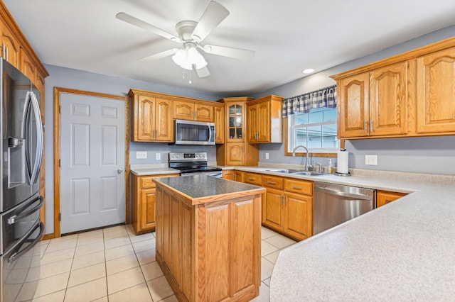 kitchen with ceiling fan, sink, a center island, stainless steel appliances, and light tile patterned floors