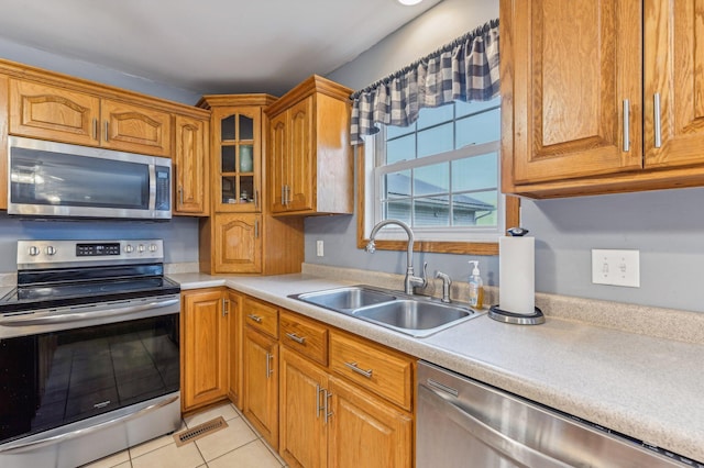 kitchen featuring light tile patterned floors, sink, and appliances with stainless steel finishes