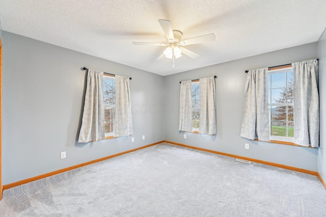 unfurnished room featuring ceiling fan, carpet floors, and a textured ceiling