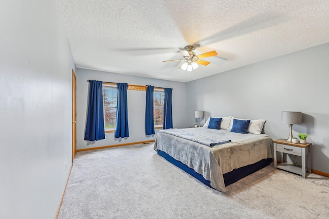 bedroom featuring ceiling fan, carpet floors, and a textured ceiling